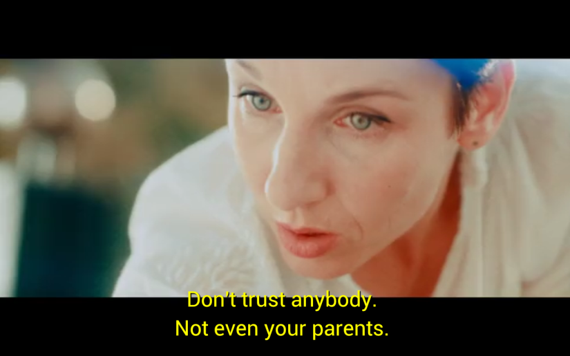 close up of a middle-aged woman speaking to her daughter, telling her "Don't trust anybody. Not even your parents."